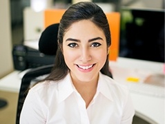 Smiling young woman sitting at office desk