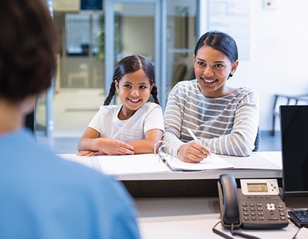 Mother and daughter at reception desk