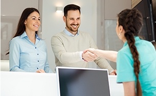 Man and woman checking at dental reception desk