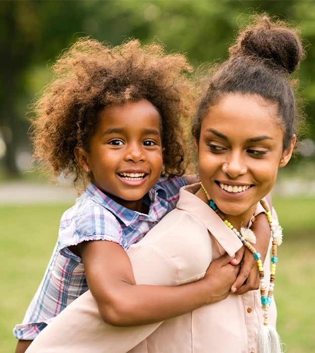 Mother and daughter smiling outdoors