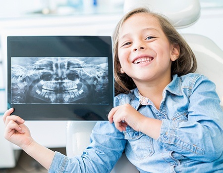 Little girl holding up her dental x-rays