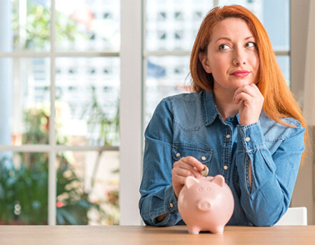woman putting money into a piggy bank