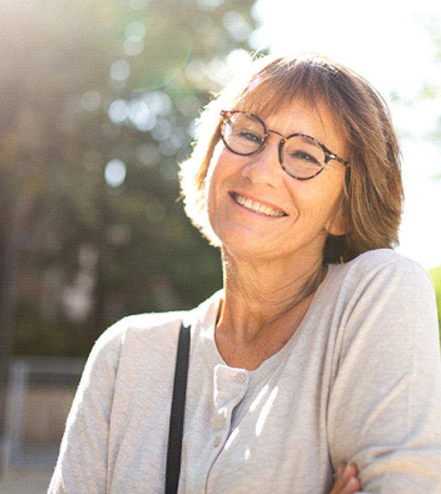 Senior woman walking down a street and smiling