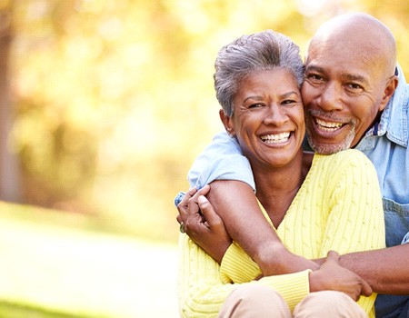 Senior man and woman hugging and smiling outside