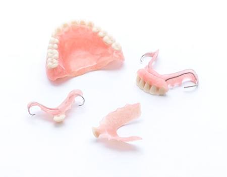 A full denture in Spring House, PA next to multiple partial dentures