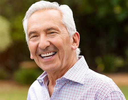 Cheerful senior man standing outside and smiling