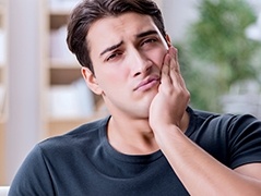 Man holding his cheek in pain