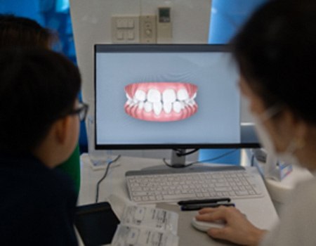 Dentist and patient looking at initial scan of patient's teeth