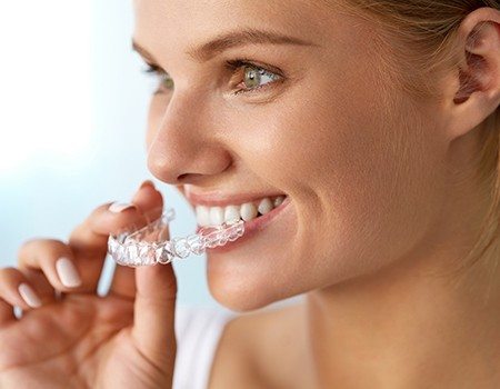 Woman placing Invisalign tray