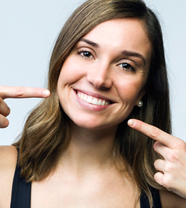 Woman pointing to her beautiful smile