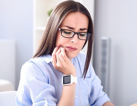 Woman holding jaw in pain