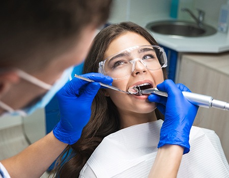 A dentist performing a root canal on a woman