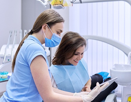 A dentist showing their patient a list of payment options