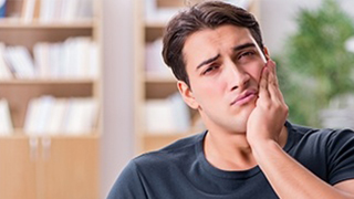 Man in pain holding jaw