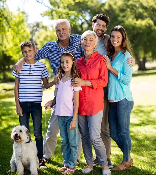 Three generations of family smiling together outdoors