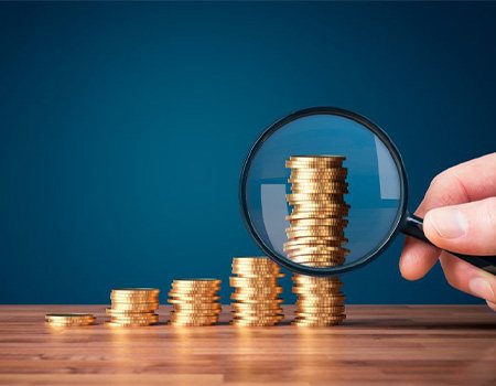 Stacks of coins examined with magnifying glass