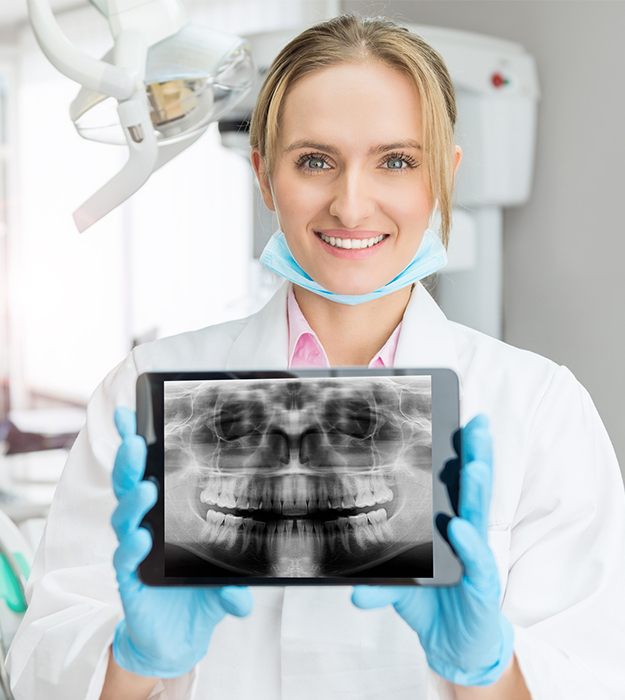 Dentist holding dental x-rays on tablet computer
