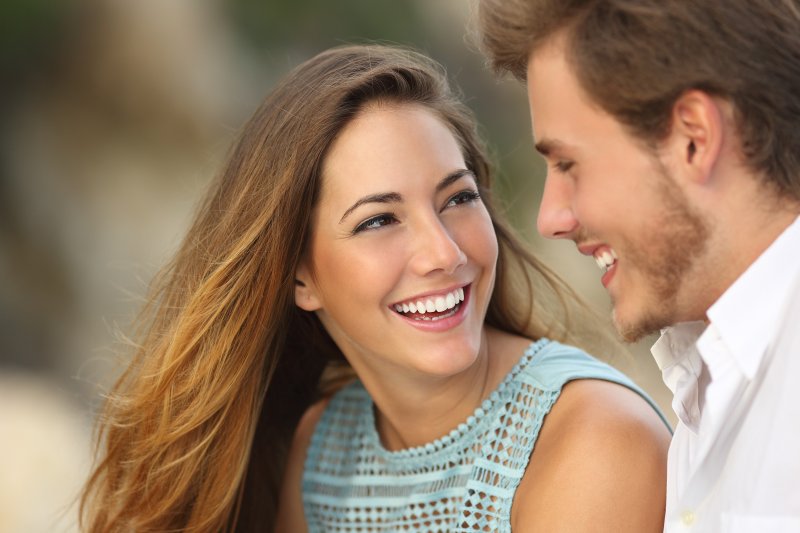 a young man and woman smiling at each other while outside