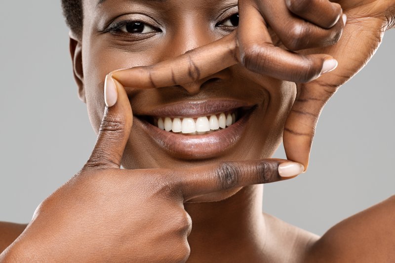 girl framing her smile with her hands