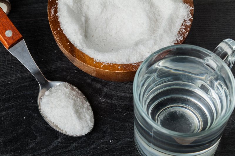 spoon of salt next to glass of water