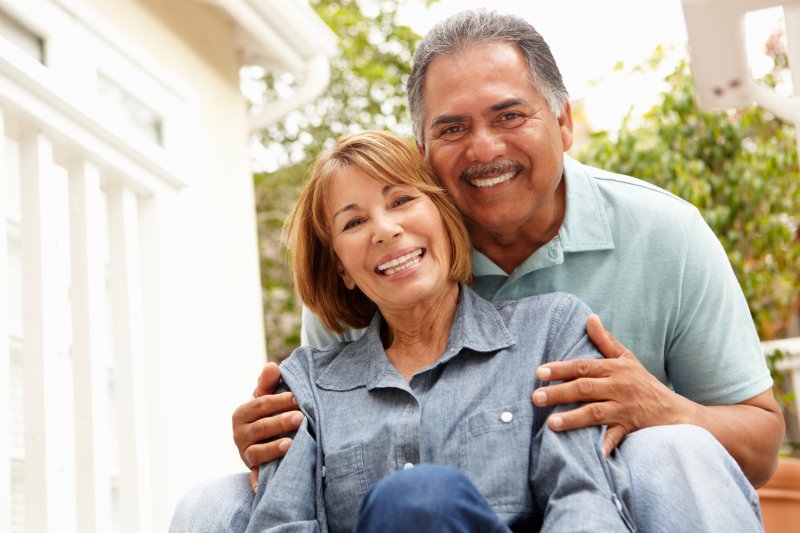 older couple smiling and relaxing in garden