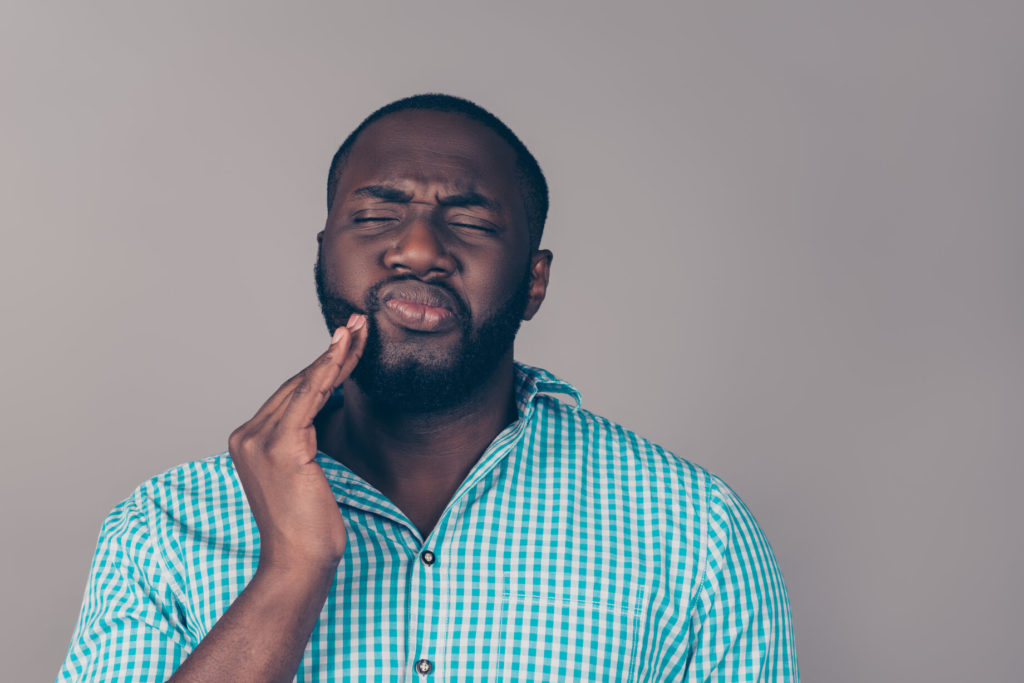 person holding check due to tooth pain