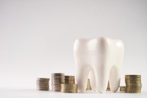 tooth next to stacks of coins