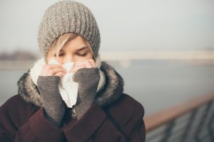 woman with a cold blowing her nose