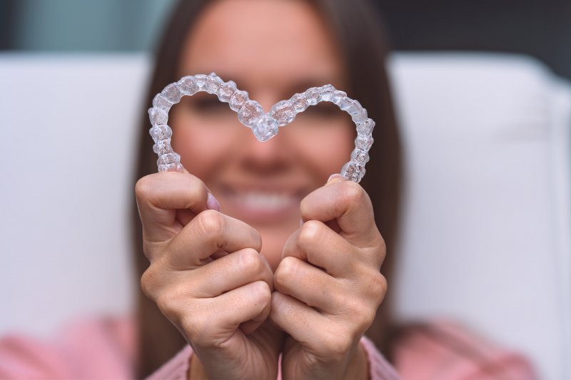 young woman holding invisalign aligners