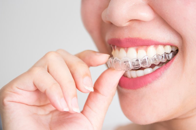 Young woman putting on her Invisalign aligner