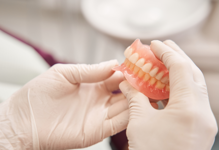 Dentist holding dentures
