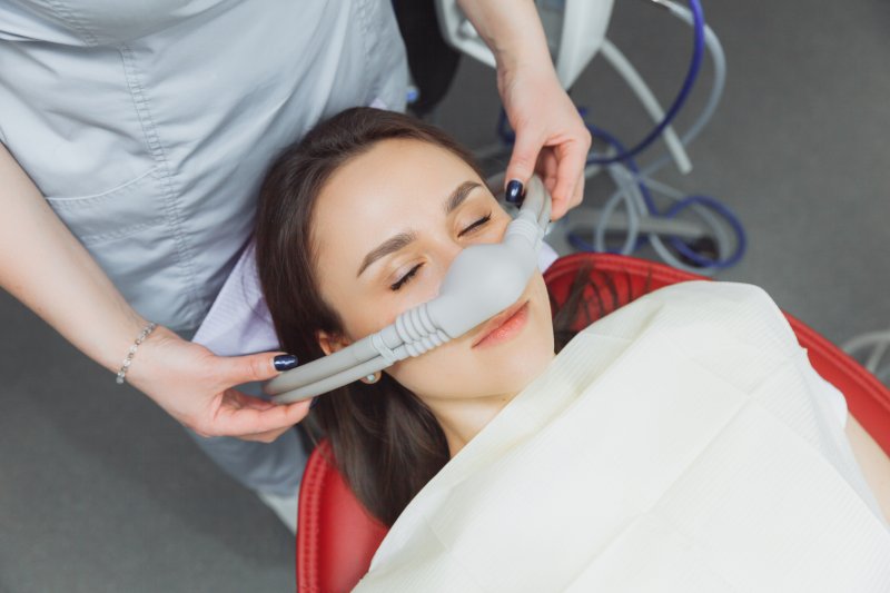 An adult woman wearing a nasal mask to inhale a sedative.